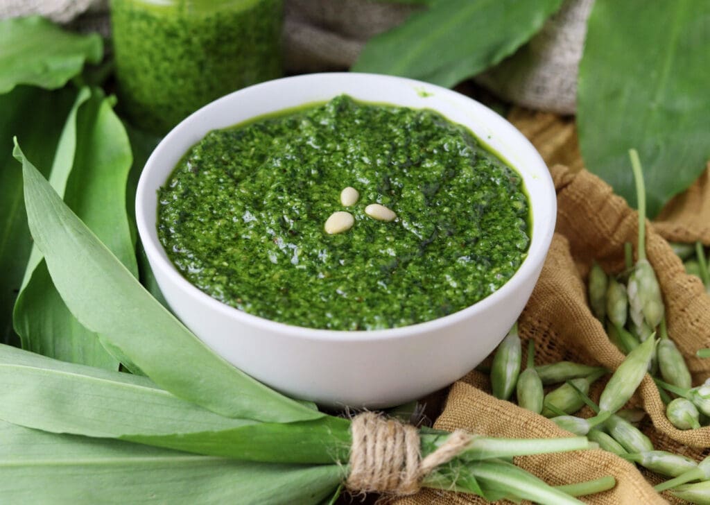 Wild garlic leaves blended into a delicious pesto with wild garlic and pine nuts, served in a small bowl.